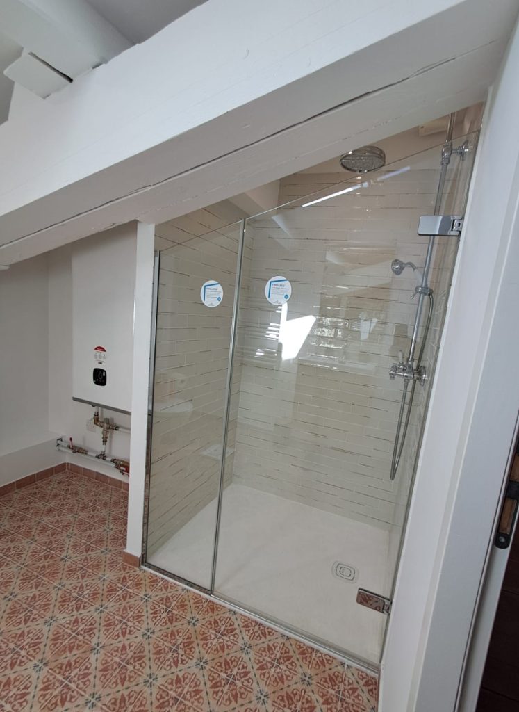 Pare-douche découpé sur mesure, adapté au mur en pente